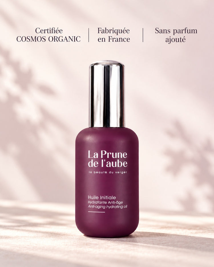 Flacon de l’Huile Initiale avec ses engagements : certification COSMOS ORGANIC, fabrication française et sans parfum ajouté. Certifiée COSMOS ORGANIC — Fabriquée en France — Sans parfum ajouté